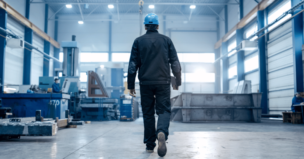 Stock Image of man walking away in factory